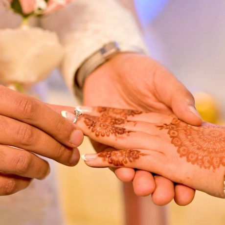 Man placing ring on bride’s mehndi hand Halal, modest US Muslim matrimony services promoting respectful unions